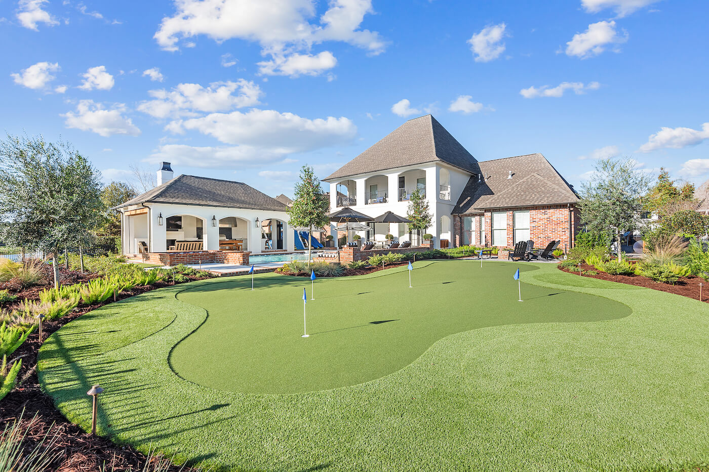 Landscape Design Baton Rouge LA - An image of a outdoor landscape design by Square One Landscape Group, showcasing the exterior of a home and a home "putting green".